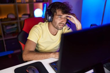 İspanyol asıllı genç adam oyun odasında bilgisayar kullanarak strese girdi.