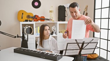 Tutkulu İspanyol erkek ve kadın müzisyenler hoş bir müzik stüdyosunda melodik bir piyano dersine daldılar.