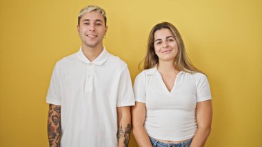 Güzel çift gülümsüyor. Birbirlerine güveniyorlar. Sarı arka planda.