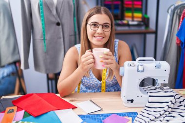 Genç, güzel İspanyol kadın terzide kahve içen kendine güvenen terzi.