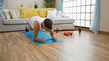 Genç Arap adam evde çekirdek egzersizi yapıyor.