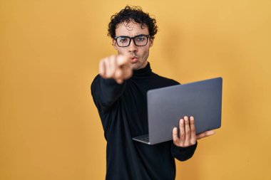 İspanyol adam bilgisayarı kullanarak kamerayı işaret ederek çalışıyor ve sen kendine güvenen ciddi bir hareket yapıyorsun. 