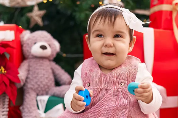 Adorable Hispanic Baby Holding Hoops Toy Sitting Floor Christmas Tree — Stock Photo, Image