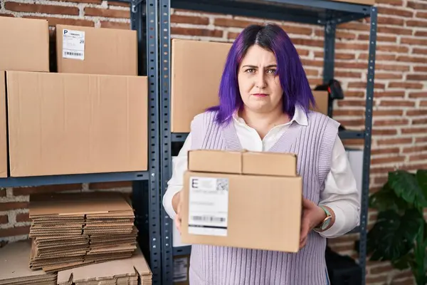另外一个身材魁梧的女人在小企业工作时 头发是紫色的 带着怀疑和紧张的盒子 皱着眉头因问题而烦恼 消极的人 — 图库照片
