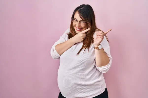 Mujer Embarazada Pie Sobre Fondo Rosa Señalando Lado Preocupado Nervioso —  Fotos de Stock