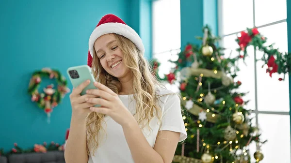 Młoda Blondynka Pomocą Smartfona Świętuje Boże Narodzenie Domu — Zdjęcie stockowe