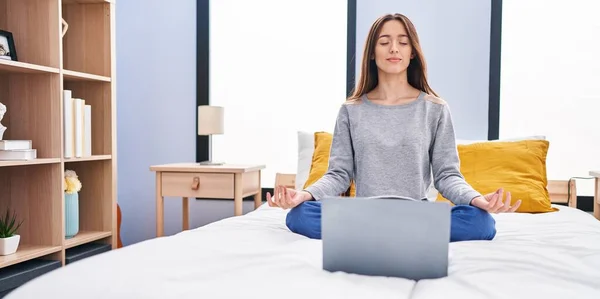 年轻美丽的惊慌失措的女人坐在床上做网上瑜伽练习 — 图库照片