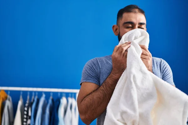 Young Hispanic Man Smelling Towel Standing Laundry Room — Fotografia de Stock