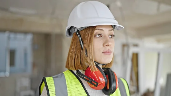 年轻的金发女建筑师站在建筑工地上 表情轻松 — 图库照片