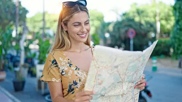Young blonde woman tourist smiling confident looking city map at street