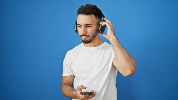 Jovem Árabe Homem Ouvindo Música Sobre Fundo Azul Isolado — Fotografia de Stock