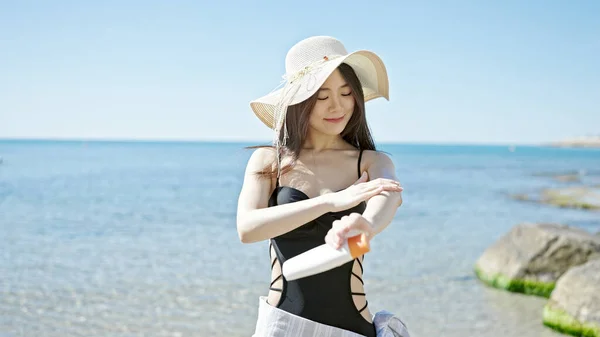Young Chinese Woman Tourist Smiling Confident Applying Sunscreen Seaside — Stock Photo, Image