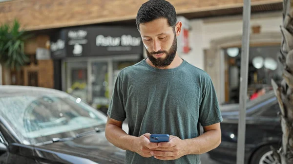 Joven Hispano Usando Smartphone Con Expresión Seria Calle — Foto de Stock