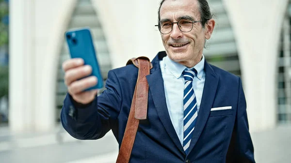 Middle age man business worker make selfie by smartphone at street