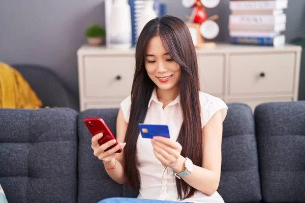 Joven Mujer China Usando Teléfono Inteligente Tarjeta Crédito Sentado Sofá — Foto de Stock