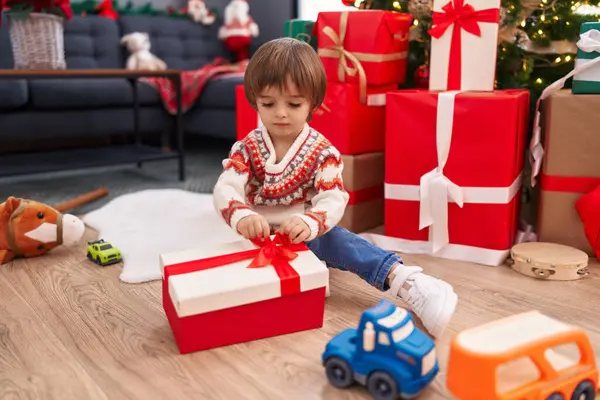 Adorable Toddler Unpacking Christmas Gift Sitting Floor Home — Stockfoto