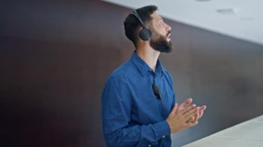 Kulaklık takmış işadamı ofiste konuşuyor, telefon görüşmesi yapıyor.