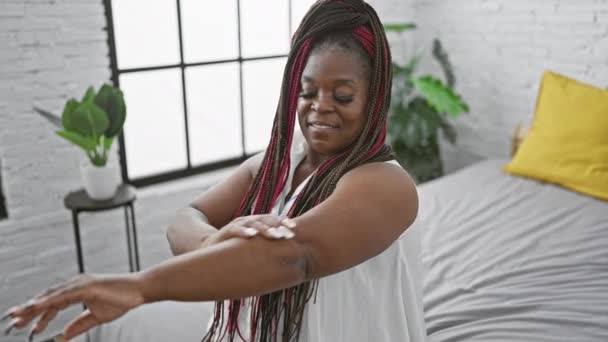 Розслаблена Афроамериканка Насолоджується Ранковим Доглядом Застосовуючи Лікування Шкіри Руках Сидячи — стокове відео