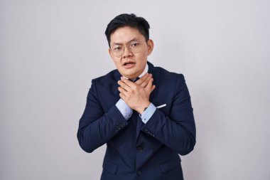 Genç Asyalı takım elbiseli ve kravatlı bir adam boğularak can çekişiyor. Sağlık problemi. Boğulma ve intihar konsepti. 