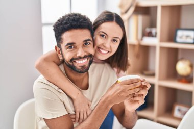 Man and woman couple sitting on table drinking coffee at home