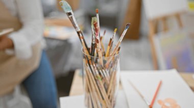 Çekici İspanyol genç adam, gri saçlı sanatçı yaratıcılığını ifade ediyor, kapalı bir sanat stüdyosunda ustaca çizim yapıyor.