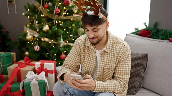 Jonge Arabier Man Met Behulp Van Smartphone Zitten Door Kerstboom — Stockfoto