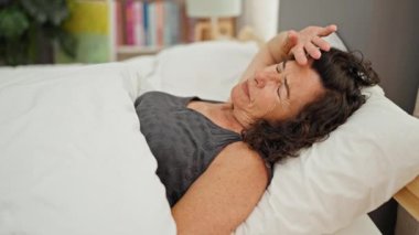 Hasta kadın yatakta yatıyor ve baş ağrısı çekiyor.