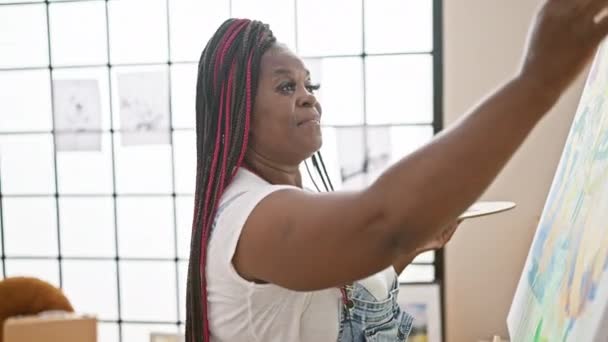 즐거운 아프리카계 미국인 예술가는 자신감으로 캔버스 서있는 그녀의 스튜디오에서 빛나는 — 비디오