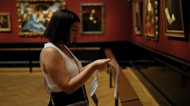 Güzel İspanyol bir kadın sanat galerisini ziyaret edip Viyana 'daki Sanat Müzesi' nde broşür okuyor.