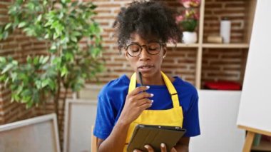 African american woman artist drawing on touchpad at art studio