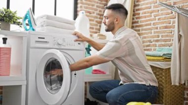 Çamaşır odasında kirli çamaşır kokusu alan İspanyol bir adam.