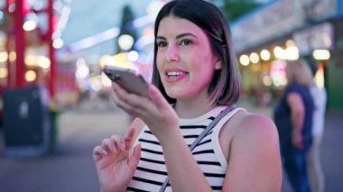 Genç ve güzel İspanyol kadın Prater Viyana 'da akıllı telefonuyla sesli mesaj yolluyor.