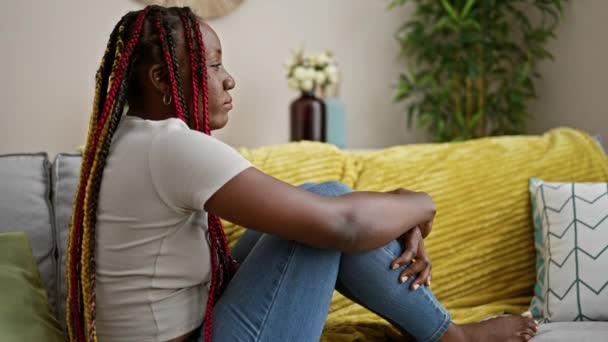 Schöne Afrikanisch Amerikanische Frau Sitzt Auf Einem Wohnzimmersofa Sportliche Zöpfe — Stockvideo
