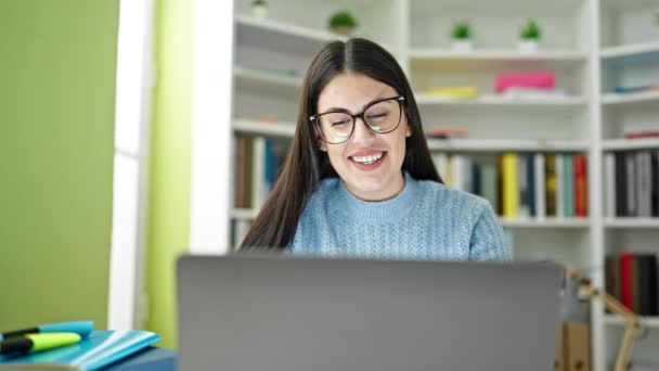 図書館大学でノートパソコンの笑顔を使用して若いヒスパニック女性学生 — ストック動画