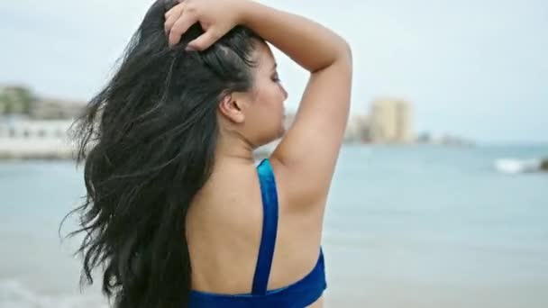 身穿比基尼的中国女游客在海滩上微笑着梳头 — 图库视频影像