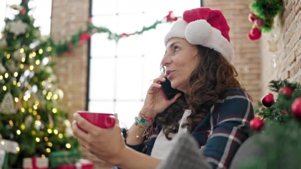 Medelålders Latinamerikanska Kvinna Talar Smartphone Dricka Kaffe Firar Jul Hemma — Stockvideo