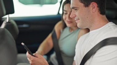 Güzel çift, caddede oturan akıllı telefonu kullanıyor.