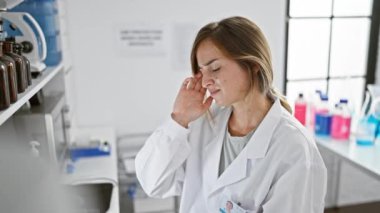 Genç, sarışın, baş ağrısı çeken bilim kadını stresli. Laboratuvardaki bilgisayarında teknolojik bir sorunla boğuşuyor..
