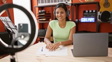 Genç Latin kadın muhabir, bir radyo programında çalışıyor. Sokakta video dersi kaydediyormuş.