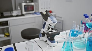 Hareketli bir laboratuvarda, genç, güzel, Latin asıllı, kısa saçlı bir bilim adamı çalışma alanında oturuyor. Konsantre olmuş, mikroskobuna bakıyor, hayati tıbbi araştırmalara katılıyor..