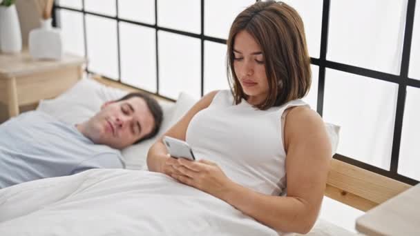 Belo Casal Deitado Cama Usando Smartphone Enquanto Namorado Dorme Quarto — Vídeo de Stock