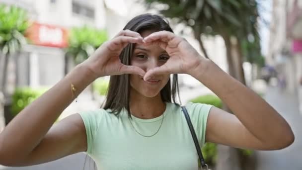 Junge Lateinische Frau Lächelt Selbstbewusst Und Macht Herz Geste Mit — Stockvideo