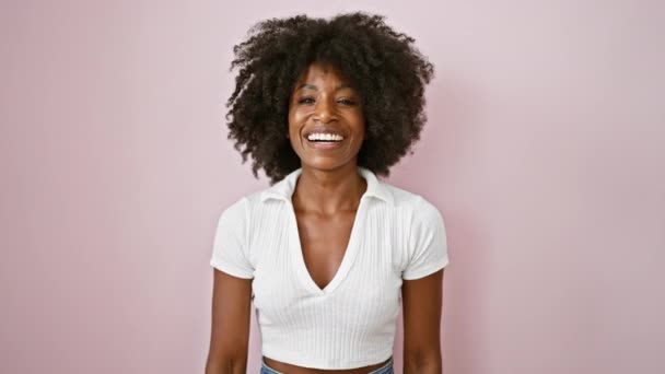 Mujer Afroamericana Sonriendo Confiada Haciendo Saludo Militar Sobre Fondo Rosa — Vídeo de stock