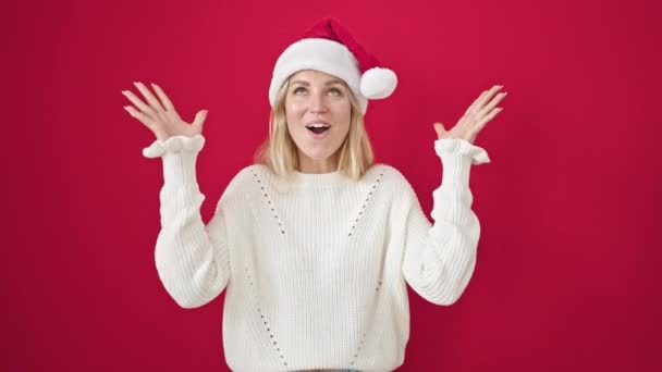 Mujer Rubia Joven Expresión Sorpresa Usando Sombrero Navidad Sobre Fondo — Vídeo de stock