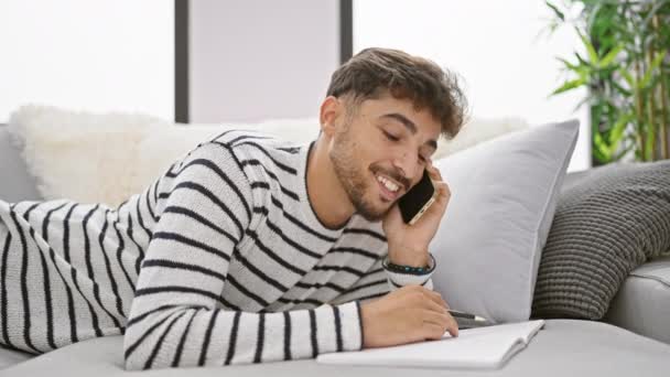 Переповнений Літературою Молодий Арабський Чоловік Впевнено Посміхається Розмовляючи Телефону Пишучи — стокове відео