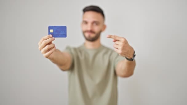 Ung Latinamerikansk Man Ler Säker Pekar Kreditkort Över Isolerade Vit — Stockvideo