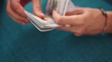 Genç İspanyol adam yemek salonunda dolar sayıyor.