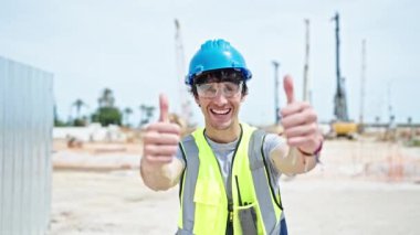 Genç İspanyol mimar inşaatta kendine güvenen ve el hareketi yapan.