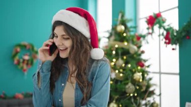 Genç, güzel, İspanyol bir kadın telefonda Noel 'i evde kutluyor.