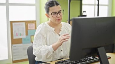 Ofisteki bilgisayar işini bitiren genç, güzel İspanyol kadın.